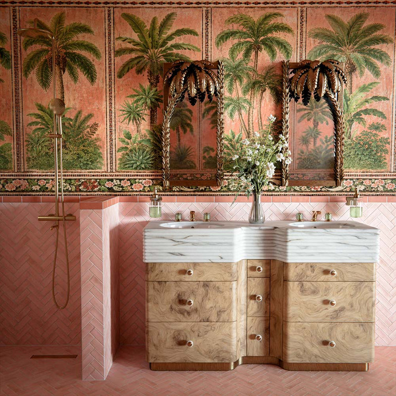 Bathroom vanity area featuring Benomar Moroccan-style brick tiles in soft blush and ivory tones, installed vertically as a statement wall, styled with a fluted pink basin, brushed brass tap, marble surface, and greenery.