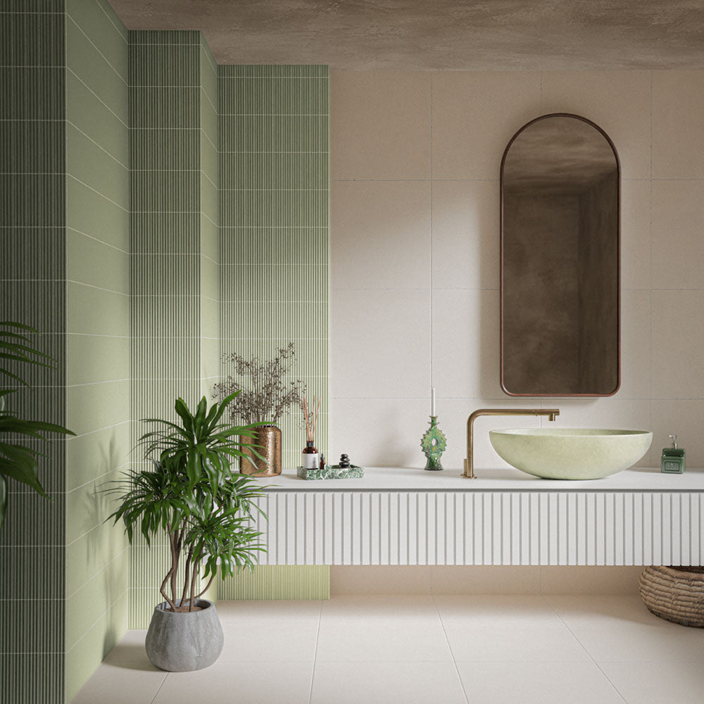 Bathroom featuring Gallery 3D Fluted Decor Tansy Green Matt 5cm x 20cm wall tiles, paired with large neutral tiles, a floating vanity, vessel basin, arched mirror and greenery.