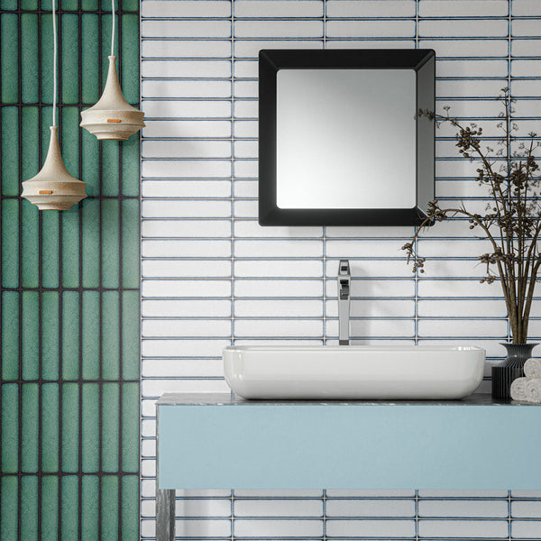 Alchemy Magma White 6.5cm x 30cm wall tiles installed horizontally around a modern bathroom vanity, paired with contrasting Alchemy Hunter Green tiles, a white countertop basin and contemporary black-framed mirror.