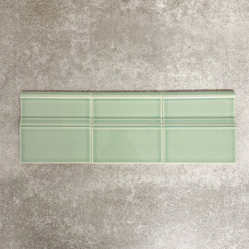 Pimlico Lime Green 15 × 15cm ceramic skirting tiles with a crackle glaze finish, featuring a soft green tone and moulded detail, designed to create a smooth transition between tiled walls and floors.
