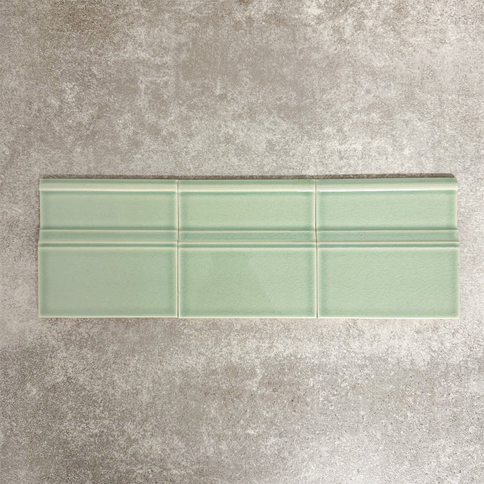 Pimlico Lime Green 15 × 15cm ceramic skirting tiles with a crackle glaze finish, featuring a soft green tone and moulded detail, designed to create a smooth transition between tiled walls and floors.
