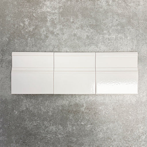Pimlico White 15 × 15cm ceramic skirting tiles with a crackle glaze finish, featuring soft white tones and moulded detailing, designed to create a neat transition between tiled walls and floors.