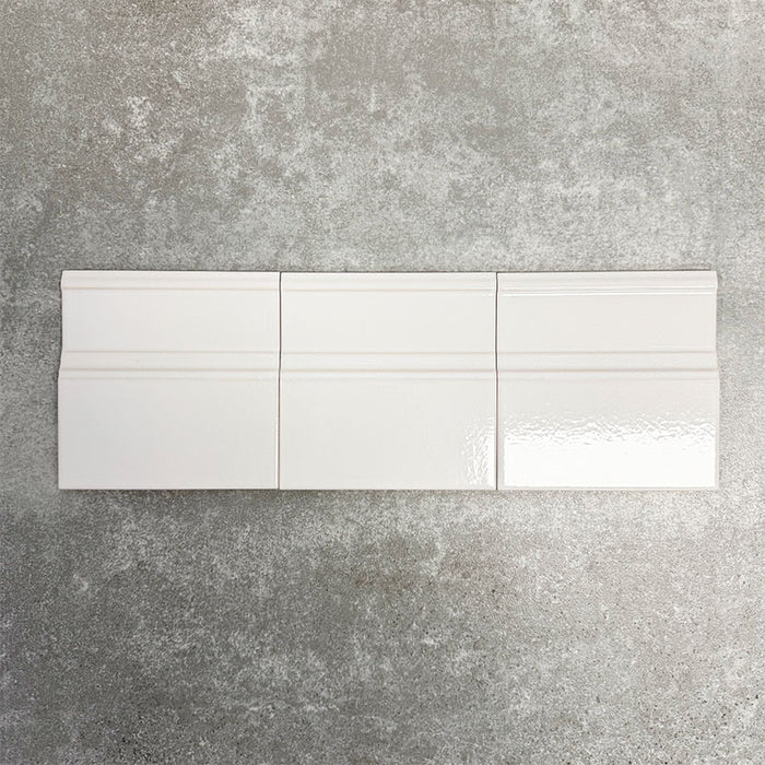 Pimlico White 15 × 15cm ceramic skirting tiles with a crackle glaze finish, featuring soft white tones and moulded detailing, designed to create a neat transition between tiled walls and floors.
