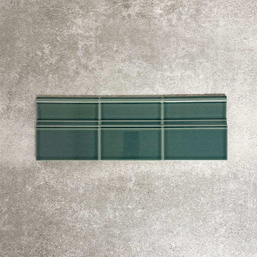 Pimlico Golders Green 15 × 15cm ceramic skirting tiles with a crackle glaze finish, featuring rich green tones and moulded detailing, designed to create a neat transition between tiled walls and floors.