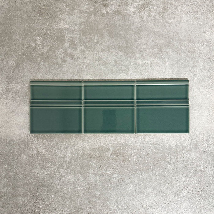 Pimlico Golders Green 15 × 15cm ceramic skirting tiles with a crackle glaze finish, featuring rich green tones and moulded detailing, designed to create a neat transition between tiled walls and floors.