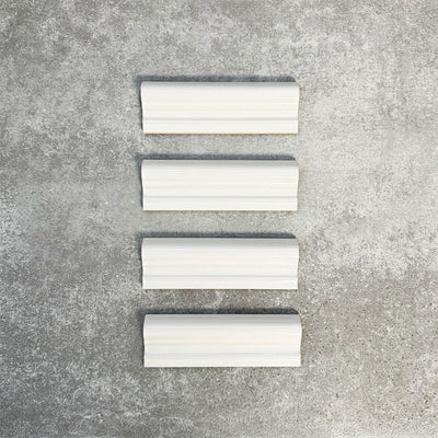 Pimlico White dado trim tiles measuring 5 × 15cm, finished with a crackle glaze and soft white tone, designed to add a decorative feature line and classic detail to ceramic wall tile layouts.