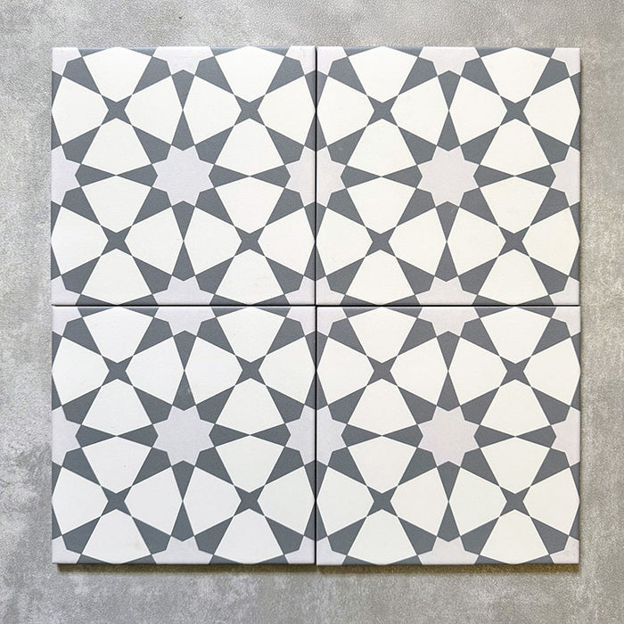 Agadir Silver Moroccan-style 20x20cm porcelain tiles shown as a four-tile layout, featuring a soft grey and white geometric star pattern with a clean, modern Moroccan look.