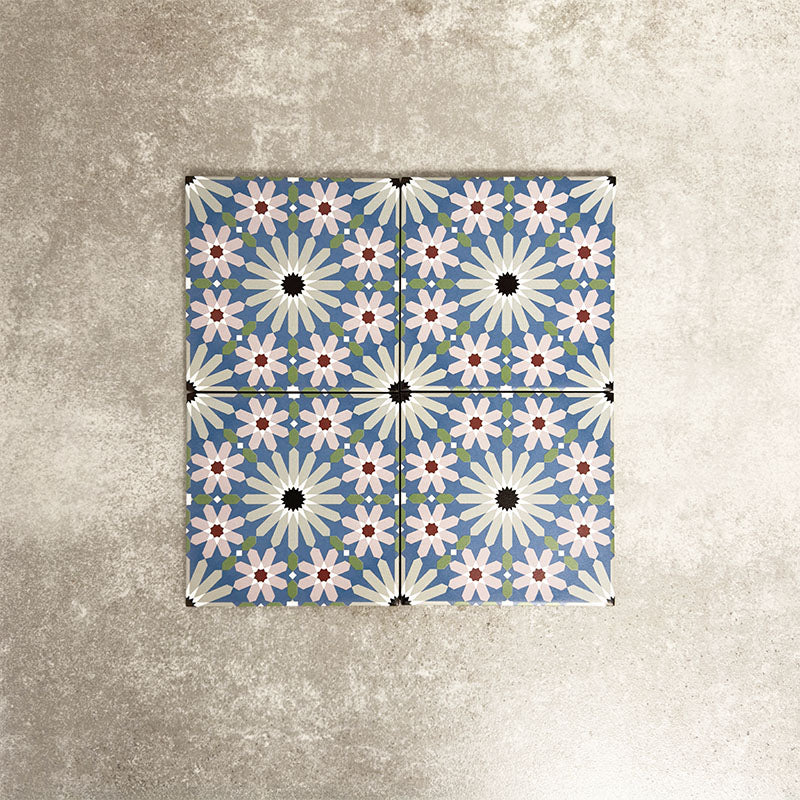 Fez Mini Artisan 15x15cm Moroccan-style porcelain tile displayed against a textured grey background, highlighting the intricate multicolour geometric star pattern in soft blue, blush pink, green and terracotta tones with an encaustic-inspired finish.