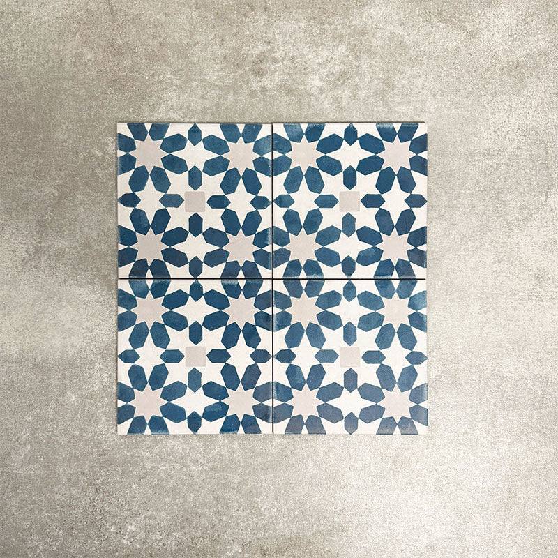 Souk Blue C 20×20cm Moroccan-style porcelain tiles arranged in a blue, white and grey geometric pattern.