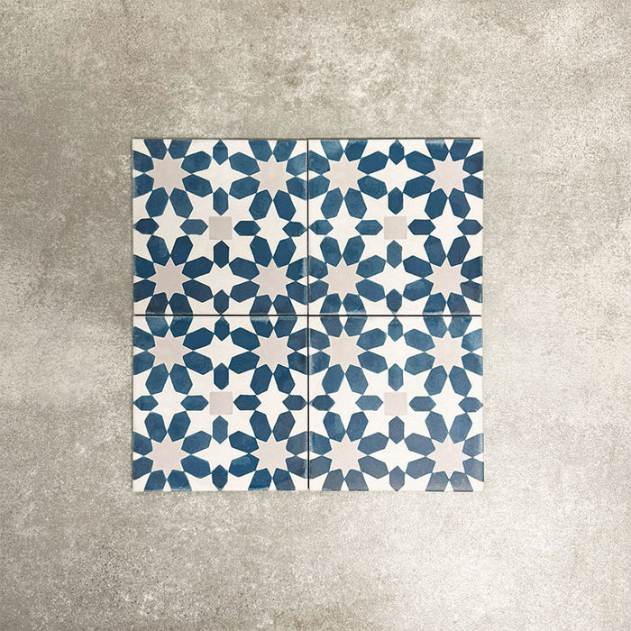 Souk Blue C 20×20cm Moroccan-style porcelain tiles arranged in a blue, white and grey geometric pattern.