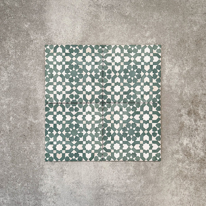 Four Berber Tetuan Green 15×15cm Moroccan-style porcelain tiles arranged together, highlighting the green and cream geometric pattern on a neutral background.