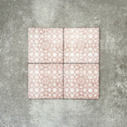 Four Berber Tetuan Rose 15×15cm Moroccan-style porcelain tiles arranged together, highlighting the soft pink and cream geometric pattern on a neutral background.