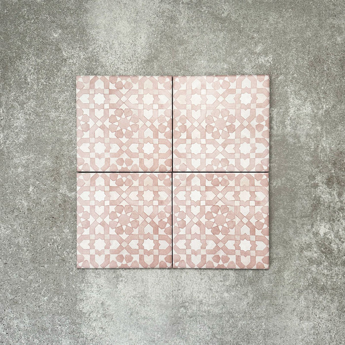 Four Berber Tetuan Rose 15×15cm Moroccan-style porcelain tiles arranged together, highlighting the soft pink and cream geometric pattern on a neutral background.