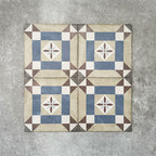 Viscount Harley Street 20×20cm Victorian-style porcelain wall and floor tiles laid in a repeating geometric square pattern with a central floral motif in soft blue, beige, warm grey and white tones, shown as a full tile layout with subtle tonal variation and floral styling.