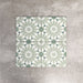Fez Jade Green 20x20cm Moroccan-style porcelain tile displayed against a textured grey background, highlighting the soft green geometric star pattern and traditional encaustic-inspired design.