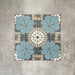 Four Nantes Azul Blue Moroccan-style tiles arranged to show the full pattern repeat. The 20x20cm tiles combine soft blue floral motifs with a central circular mosaic detail in cream, grey and stone tones, forming a symmetrical, traditional Moroccan-inspired design suitable for floors and walls.