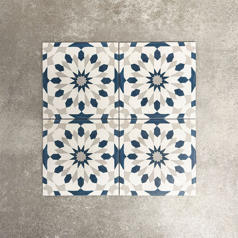 Souk Blue A 20×20cm Moroccan-style porcelain tiles arranged in a blue, white and grey geometric pattern.