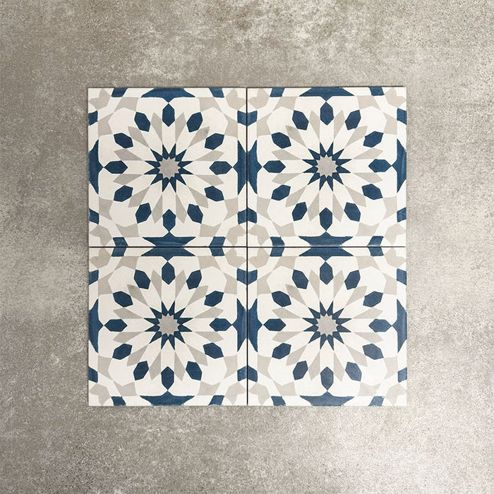 Souk Blue A 20×20cm Moroccan-style porcelain tiles arranged in a blue, white and grey geometric pattern.