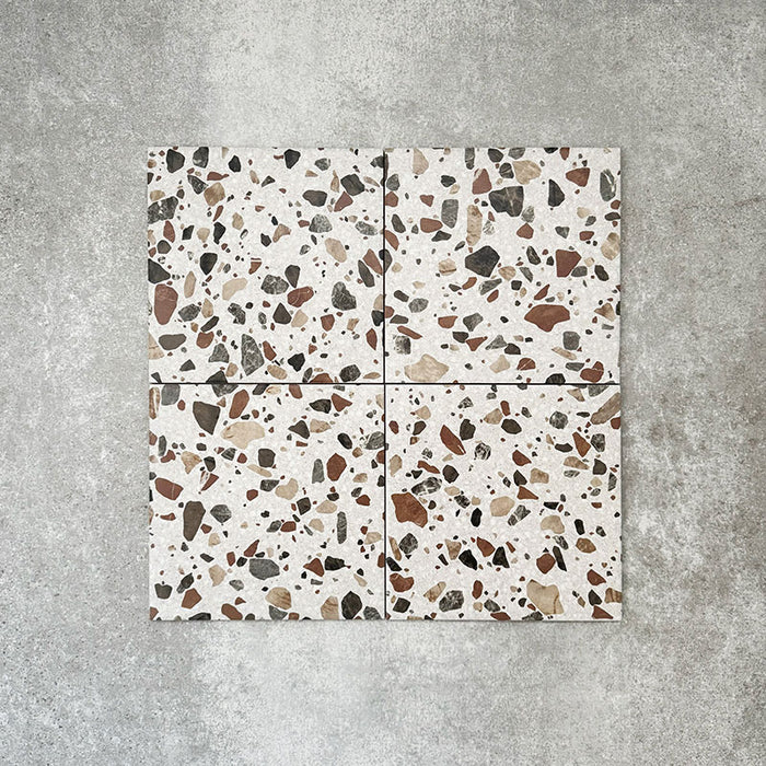 Turin Terrazzo Blanco Drops porcelain tile in a 20 × 20cm format, featuring a terrazzo-style design with larger scattered stone fragments in warm neutral tones on a light base, shown on a neutral background to highlight the texture and pattern suitable for wall and floor use.