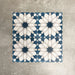 Souk Blue D 20×20cm Moroccan-style porcelain tiles arranged in a blue, white and grey geometric pattern.