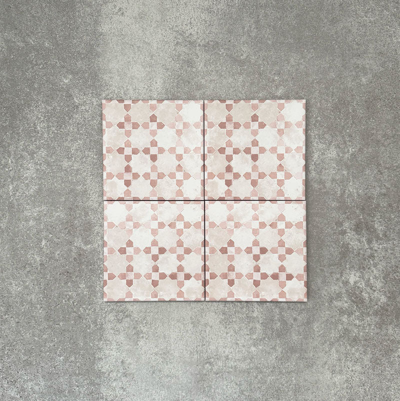 Four Berber Mequinez Rose 15×15cm Moroccan-style porcelain tiles arranged together, highlighting the soft pink and cream geometric pattern on a neutral background.