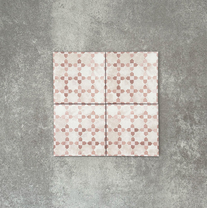 Four Berber Mequinez Rose 15×15cm Moroccan-style porcelain tiles arranged together, highlighting the soft pink and cream geometric pattern on a neutral background.