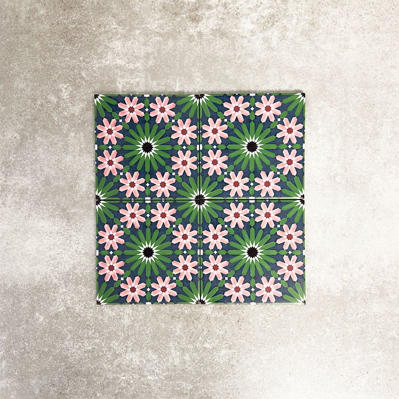 Fez Mini Autumn Moroccan-style porcelain tile shown as a single tile, featuring an intricate geometric star pattern in deep green, soft blush pink, charcoal and white. The 15 × 15cm tile highlights the detailed encaustic-effect design and rich autumnal colour palette, ideal for adding decorative interest to walls or floors.