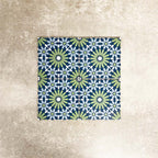 Fez Mini Springs 15x15cm Moroccan-style porcelain tiles arranged as a four-tile panel, highlighting the full repeat design with layered blue and soft green geometric star motifs against a textured grey background.