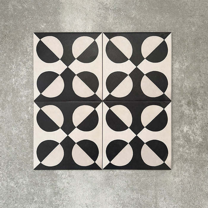 Abstract Illusion Noir Patterned Tiles in a 20x20cm format, displayed in a repeated grid layout to showcase the bold optical illusion design. High-contrast black and soft cream curved shapes create a striking geometric pattern, styled with floral accents to highlight the tiles as a statement choice for feature walls, floors or decorative splashbacks.