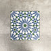 Fez Ocean Blue 20x20cm Moroccan-style porcelain tiles arranged as a four-tile panel, highlighting the blue, white and green geometric star pattern and the full repeat design against a textured grey background.