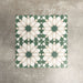 Souk Green D 20×20cm Moroccan-style porcelain tiles arranged in a green, white and beige geometric pattern.