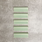 Pimlico Lime Green dado trim tiles measuring 5 × 15cm, finished with a crackle glaze and soft green tone, designed to add a decorative feature line and classic detail to ceramic wall tile installations.