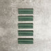 Pimlico Golders Green dado trim tiles measuring 5 × 15cm, finished with a crackle glaze and rich green tone, designed to add a decorative feature line and classic detailing to ceramic wall tile installations.
