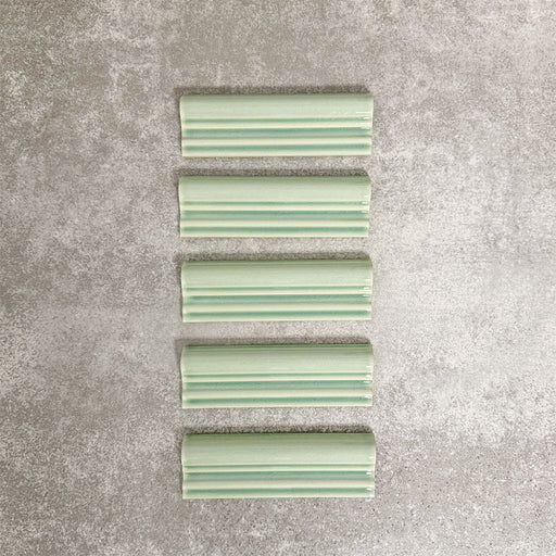Pimlico Lime Green dado trim tiles measuring 5 × 15cm, finished with a crackle glaze and soft green tone, designed to add a decorative feature line and classic detail to ceramic wall tile installations.