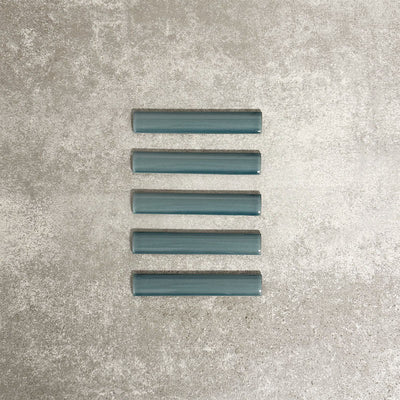 Pimlico River Blue pencil trim tiles measuring 2.5 × 15cm, finished with a crackle glaze and rich blue tone, designed to neatly frame ceramic wall tiles and add a subtle decorative edge.