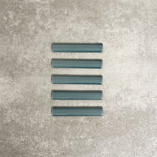 Pimlico River Blue pencil trim tiles measuring 2.5 × 15cm, finished with a crackle glaze and rich blue tone, designed to neatly frame ceramic wall tiles and add a subtle decorative edge.