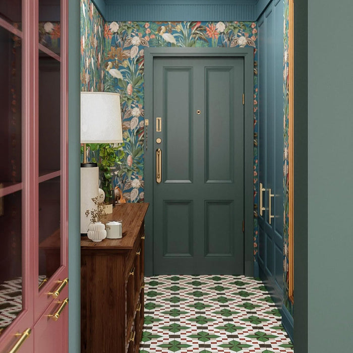 Hallway interior featuring Abstract Compass Green 20x20cm patterned floor tiles in green, white and red tones, styled with teal panelling, botanical wallpaper, wooden console table, and decorative accessories in a characterful entrance space.