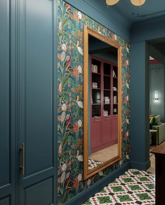 Hallway interior featuring Abstract Compass Green 20x20cm patterned floor tiles in green, white and red tones, styled with teal panelling, botanical wallpaper, wooden console table, and decorative accessories in a characterful entrance space.