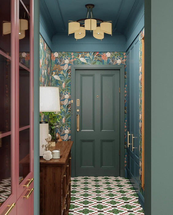 Hallway interior featuring Abstract Compass Green 20x20cm patterned floor tiles in green, white and red tones, styled with teal panelling, botanical wallpaper, wooden console table, and decorative accessories in a characterful entrance space.