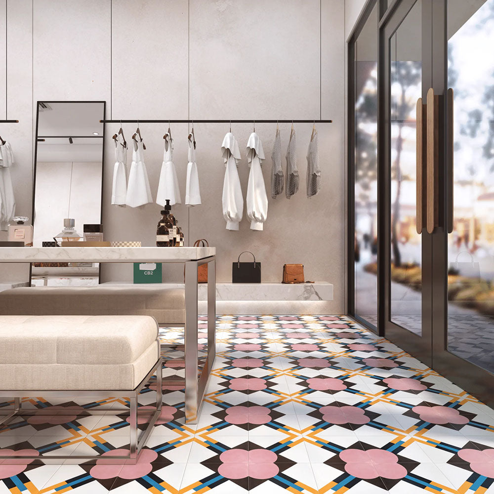 Retail interior featuring Abstract Contori Patterned Tiles in a 20x20cm format, laid as a decorative floor design. The elegant geometric pattern blends soft blush pink, muted green, mustard yellow and charcoal tones, paired with marble counters, neutral furnishings and contemporary lighting to create a refined, high-end boutique setting.