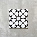 Agadir Black & White Moroccan-style 20x20cm porcelain tile featuring a bold geometric star pattern in black and white, shown as a single tile on a neutral background.