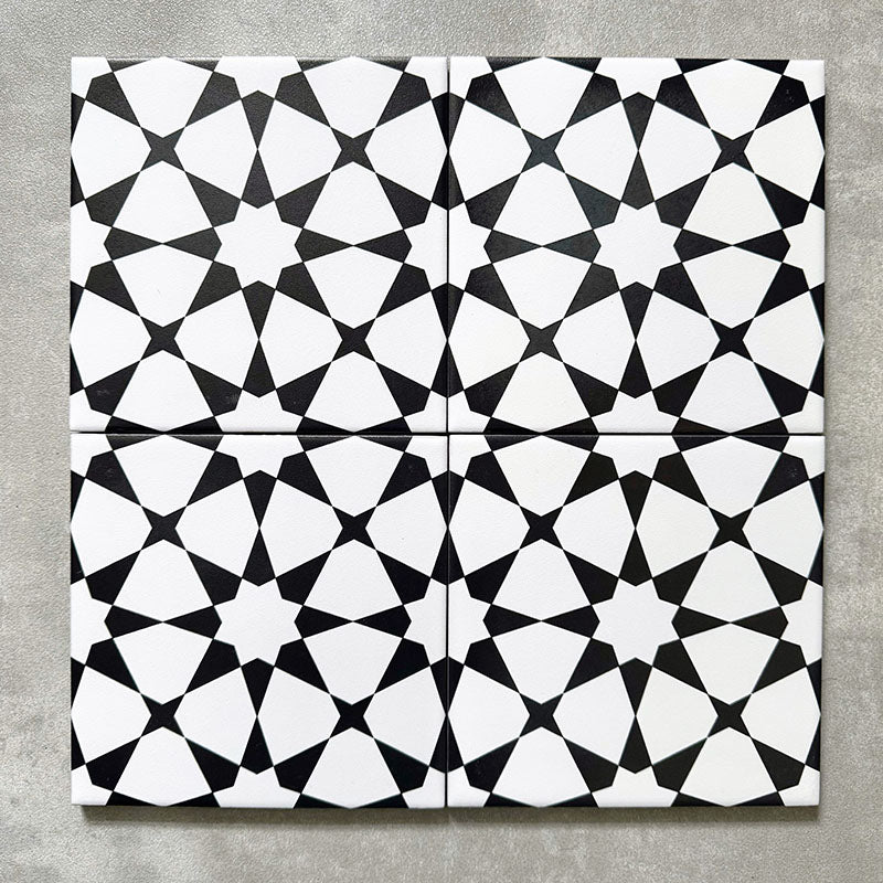 Agadir Black & White Mini Moroccan-style 15x15cm porcelain tiles arranged as four tiles, showcasing a repeating geometric star pattern in black and white on a neutral background.