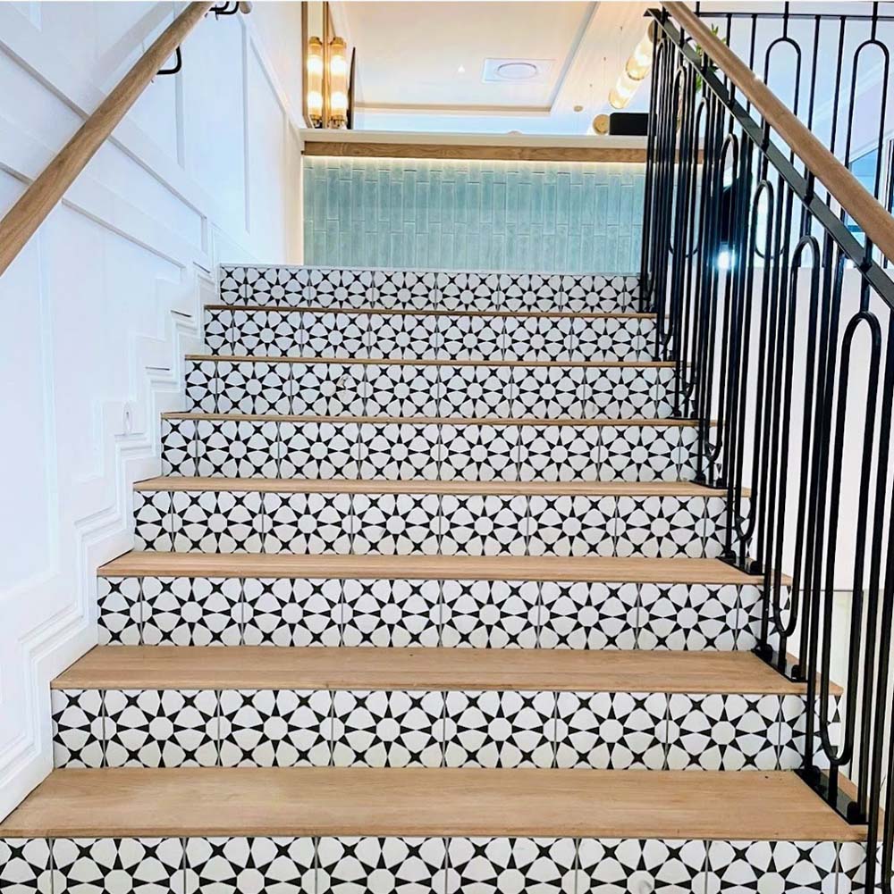 Staircase featuring Agadir Black & White Mini Moroccan-style 15x15cm porcelain tiles on the risers, showcasing a bold geometric star pattern, paired with natural wooden treads for a striking contrast.