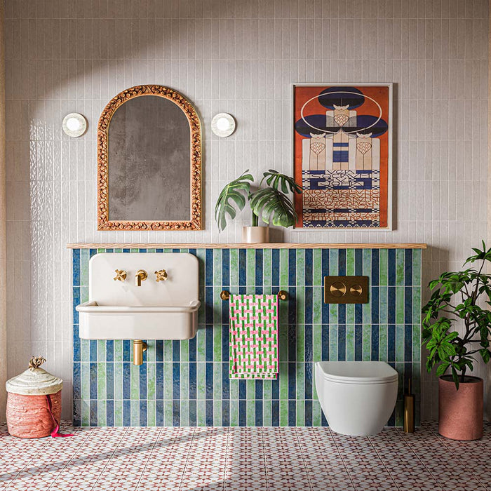 Agadir Cotto 20cm x 20cm Moroccan style tiles, featuring a repeating terracotta and white geometric pattern across the bathroom floor, paired with blue and green wall tiles, warm brass details and neutral finishes.