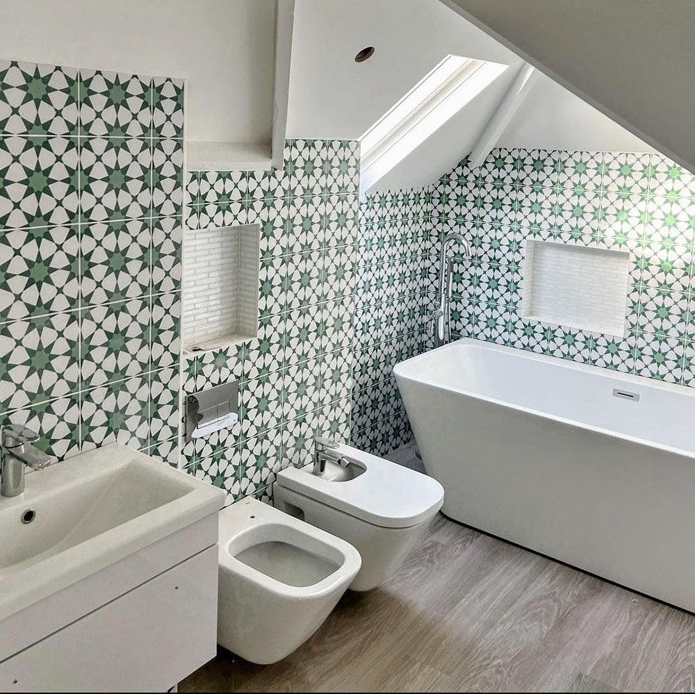 Bathroom interior featuring Agadir Green Moroccan-style 20x20cm porcelain wall tiles, showcasing a repeating geometric star pattern in green and white, styled with a freestanding bath, modern sanitaryware and a bright, airy layout.