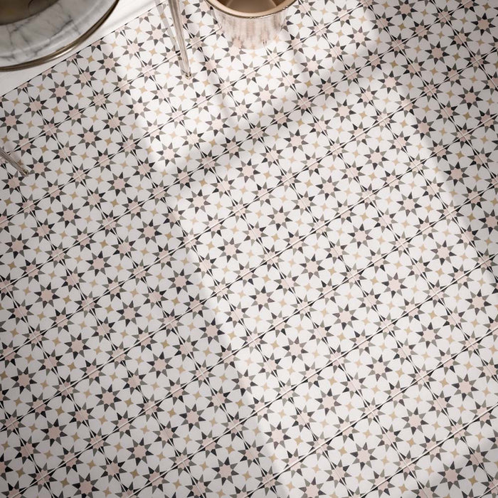 Close-up of Agadir Natural 20x20cm Moroccan-style patterned bathroom floor tiles, featuring intricate geometric star motifs in cream, grey, black and beige, arranged in a repeating decorative design.