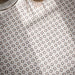 Close-up of Agadir Natural 20x20cm Moroccan-style patterned bathroom floor tiles, featuring intricate geometric star motifs in cream, grey, black and beige, arranged in a repeating decorative design.