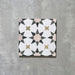 Single Agadir Natural Moroccan-style 20x20cm porcelain tile, featuring a soft neutral geometric star pattern in white with muted beige, olive and charcoal accents on a textured surface.