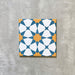 Agadir Sun and Sky Moroccan-style 20x20cm porcelain tile featuring a geometric star pattern in blue, white and warm yellow, shown as a single tile on a neutral background.