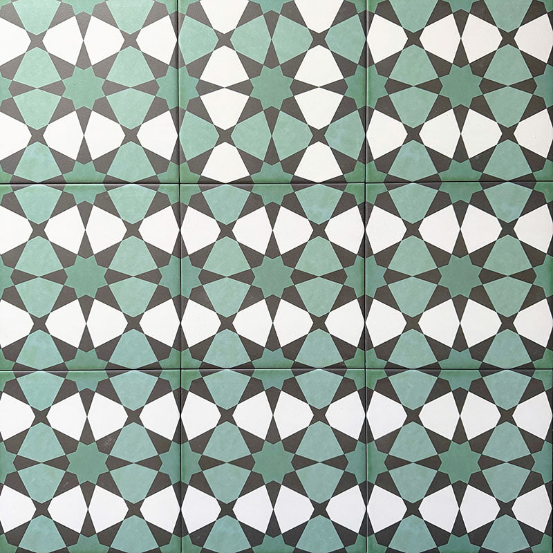 Group of Agadir Verde Moroccan-style 20x20cm porcelain tiles laid together, showcasing a repeating geometric star pattern in green, white and charcoal tones.